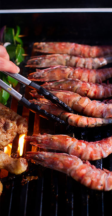 A selection of seafood, meats, and vegetables on a barbecue